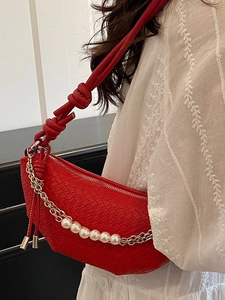 Red woven hobo bag with pearl chain detail and knotted strap on shoulder model