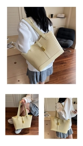 Macro shot of cream tote bag featuring crocodile pattern texture and gold buckle detail