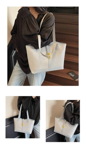 Detail of light blue faux crocodile tote bag with gold lock and thin shoulder straps