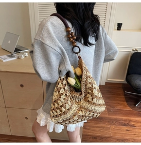 Detail of hand-woven crochet tote bag with geometric patterns and red wooden bead accents