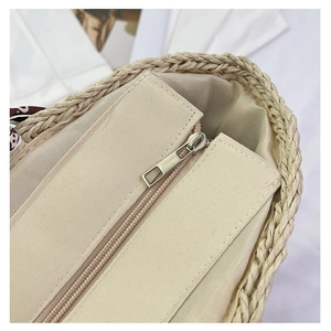 Close-up of handmade straw bag showing fine weave texture and canvas zipper closure detail