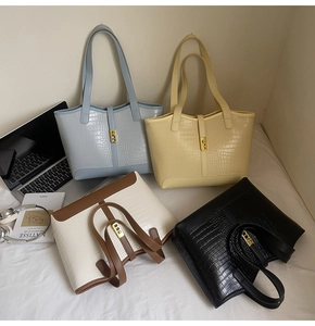 Macro detail of crocodile texture tote bags in four colors with gold metal twist locks