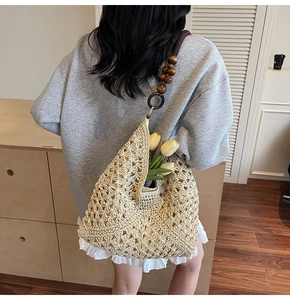 Detail of hand-woven tote bag with decorative wooden beads and rings on the shoulder strap