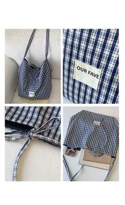 Detail view of large blue checkered canvas tote bag showing interior capacity and label