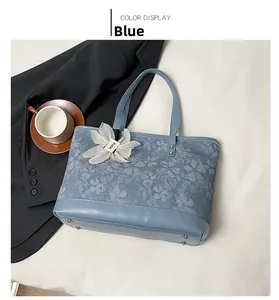 Detail of blue floral tote bag with silver rivets and mesh flower bag charm decoration
