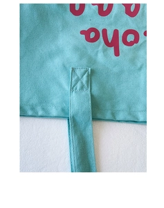 Close-up of reinforced cross-stitching on the light blue canvas tote bag handle