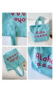 Detailed views of light blue canvas tote bag with pink Aloha lettering and stitching