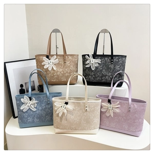 Detailed view of floral tote bags in five colors with decorative silk flower charms