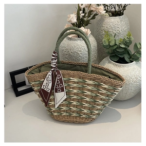 Detail view of handmade straw handbag with floral silk scarf handle and green lining