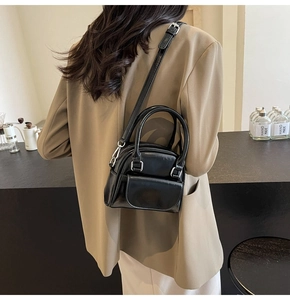 Model view of black high-gloss mini crossbody bag with silver hardware and double handles