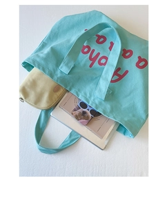 Top view of large canvas tote bag showing spacious interior with tablet and books