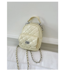Detail of cream quilted mini backpack with silver metal turn-lock and chain strap