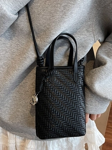 Minimalist black woven mini tote crossbody bag with leather texture and metal charm
