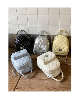 Detail of five quilted mini backpacks in various colors with metallic chain straps