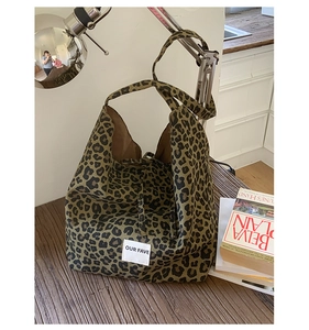 Detail of leopard print canvas tote bag featuring our fave woven label and wide strap