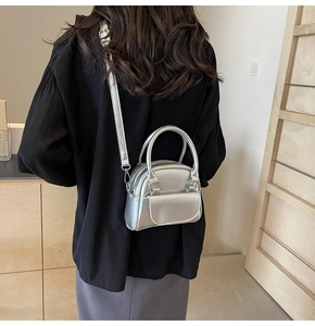 Detail showing metallic silver mini handbag with front pocket and adjustable strap