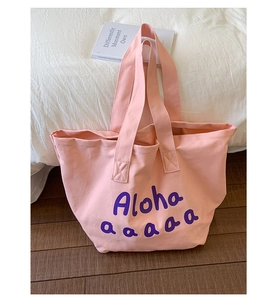 Detailed view of pink canvas tote bag with purple Aloha print and spacious interior