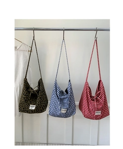 Detailed view of large canvas tote bags in leopard, blue-white, and red-white grid patterns