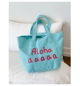 Detail of light blue canvas tote bag showing reinforced handles and pink Aloha print