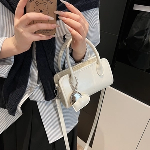 White PU bowling handbag with heart charm shown on model for size and style reference