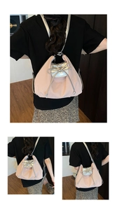 Detail view of pink pleated tote bag featuring a large silver metallic bow decoration