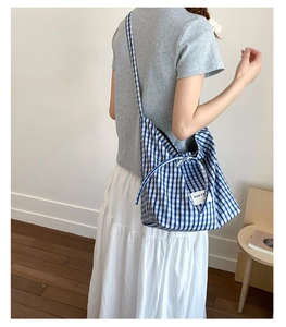 Detailed shot of large blue and white checkered canvas tote bag with woven logo label
