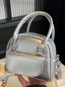 Silver metallic mini bowling bag with a front flap pocket and a detachable shoulder strap