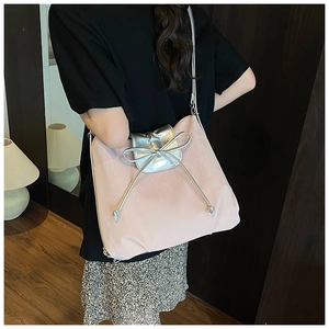 Detail of light pink tote bag with textured finish and silver knotted bow detail