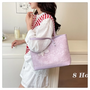 Detail of light purple floral tote bag with white flower charm and long shoulder straps