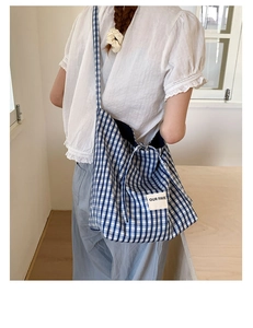 Detailed shot of large blue and white checkered canvas tote bag with Our Fave label