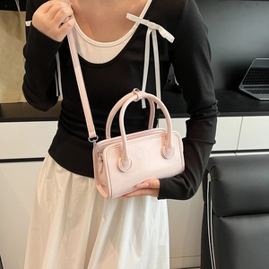 Detail of light pink PU leather bowling bag with top handles and adjustable strap