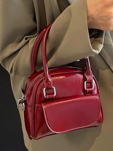 Elegant deep red patent leather mini bowling handbag with dual handles and silver hardware