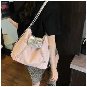 Detailansicht der pinkfarbenen Nylon-Tragetasche mit silberner Schleife und Schultergurten