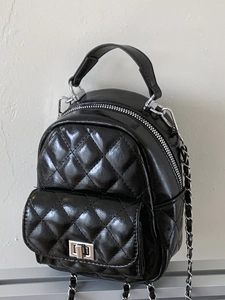 Black quilted mini backpack with silver chain strap and polished leather finish
