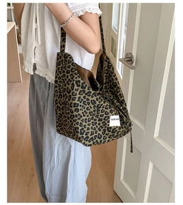 Detail of leopard print canvas tote bag featuring Our Fave logo patch on the side