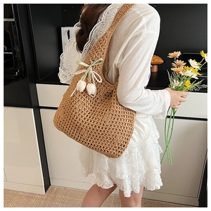 Close-up of woven tote bag with tulip charms and pearl ribbon detail for summer