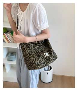 Detailed view of the woven leopard print canvas tote bag with a white fabric patch label