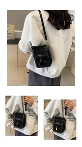 Detail of black quilted mini phone bag with golden metal logo and fine metal buckles