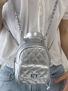 Silver quilted mini backpack for women featuring metallic chain straps and top handle