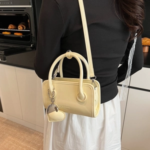 Detail of cream PU leather bowling bag with heart charm and CLEAROR embossed logo