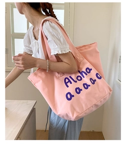 Detail of pink canvas tote bag with purple Aloha print and wide comfortable shoulder straps