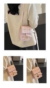 Close-up of pink quilted crossbody phone bag with fringe and metal pendant detail