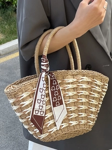 Handwoven straw tote bag with a decorative cartoon bear print scarf for summer beach style