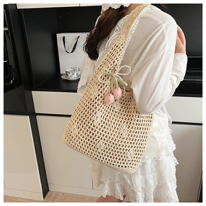 Detail of hollow woven tote bag featuring cream crochet texture and tulip pearl charms