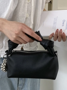 Minimalist black pleated handbag with lychee texture and silver bead pendant detail