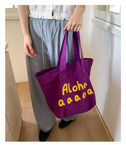 Detailed view of large purple canvas tote bag featuring vibrant yellow Aloha print