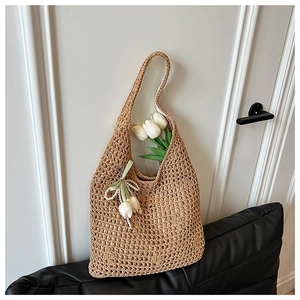 Detail of hollow woven tote bag featuring white tulip pendants and green ribbon bow decoration