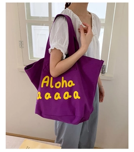 Detailed shoulder view of a large purple canvas tote bag with yellow Aloha print