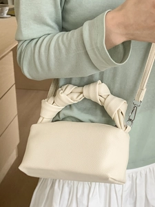 Chic beige pleated crossbody bag with twisted handle and litchi grain leather finish