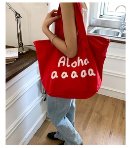 Detailed view of the large red canvas tote bag featuring white Aloha script print